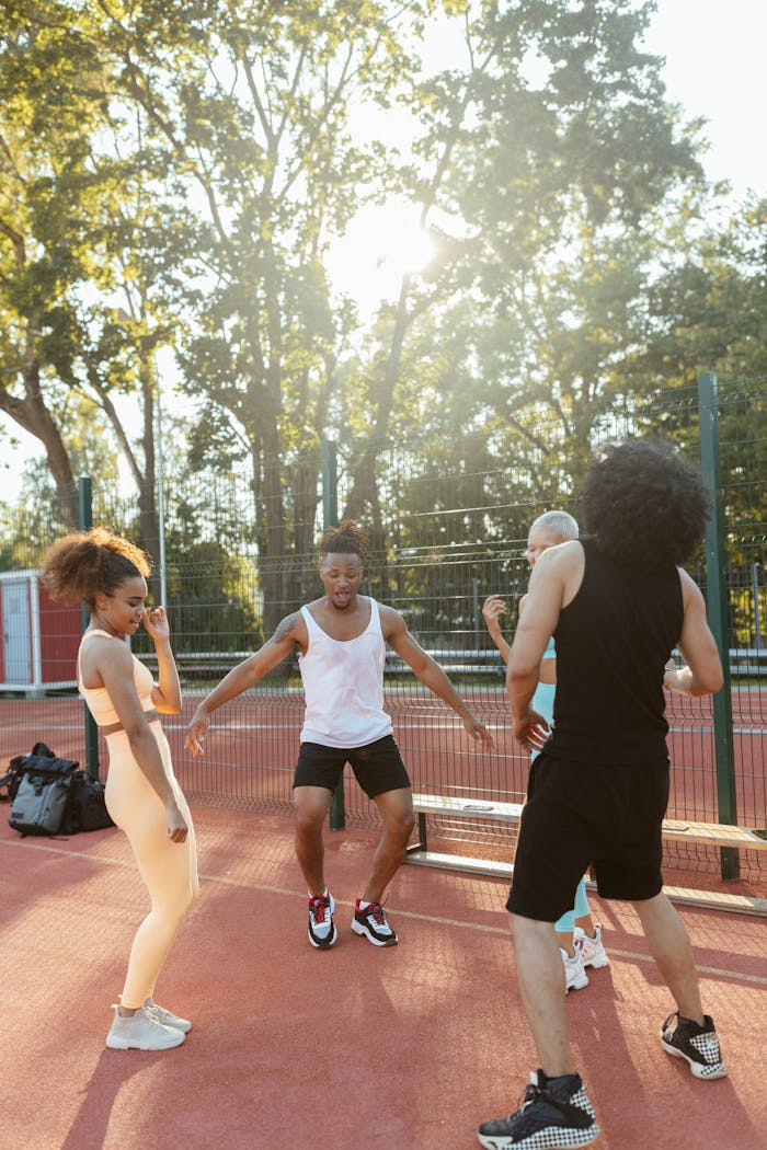Young adults having fun dancing outdoors on a sunny day, enjoying moments of leisure and recreation.